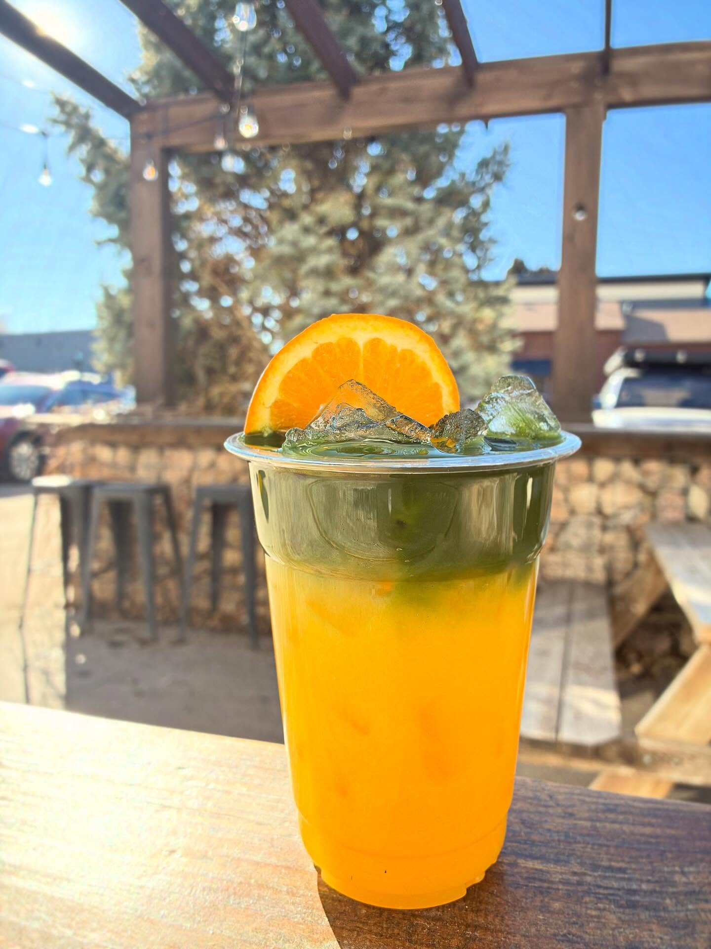 Solstice Matcha — orange juice layered with matcha, on the patio