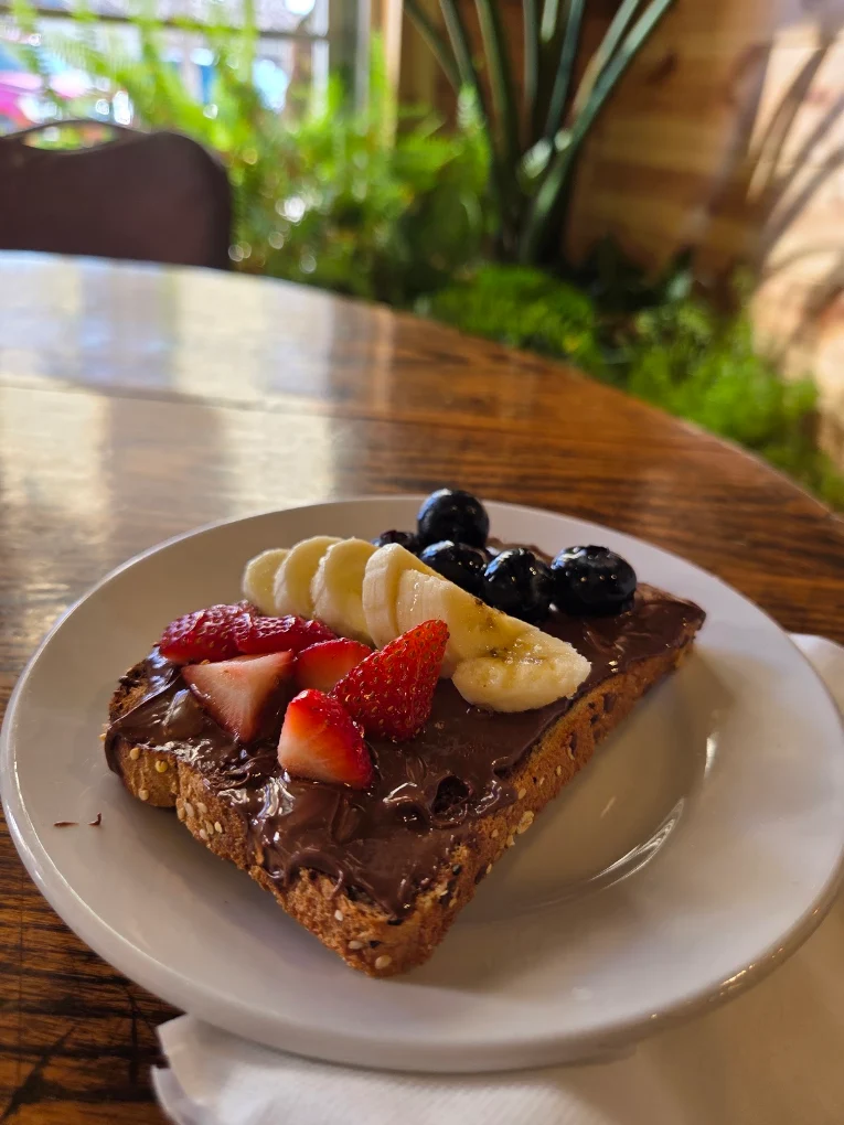 Nutella toast topped with banana, strawberries, and blueberries